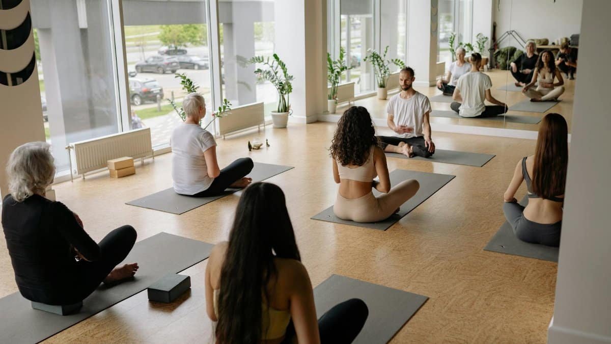 A diverse group practicing yoga indoors on mats, fostering mindfulness and health.