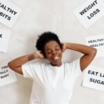 Smiling woman embracing positive lifestyle with healthy living messages around her.