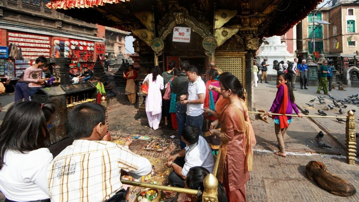 People engage in rituals at a bustling temple, showcasing cultural richness and tradition.