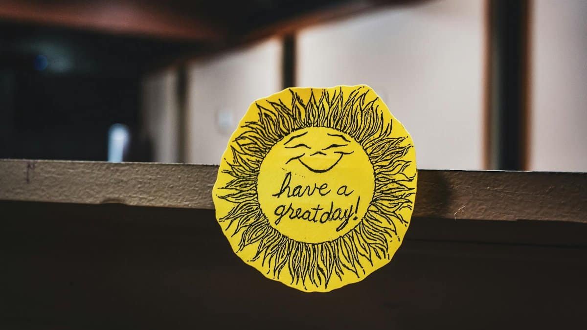 Yellow paper sun with a smile and 'Have a great day!' message on a shelf.