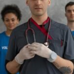 Portrait of a healthcare professional with volunteers in blue shirts, showing teamwork.