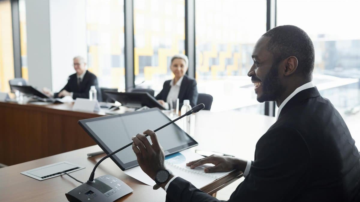 Professional business meeting with smiling participants discussing strategies at a conference table.