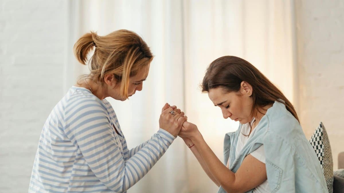 Two women sharing a moment of support and empathy indoors.
