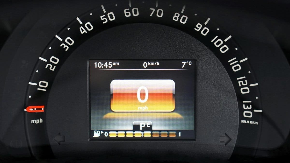 Close-up of a luxury car dashboard with a digital speedometer and sleek design features.