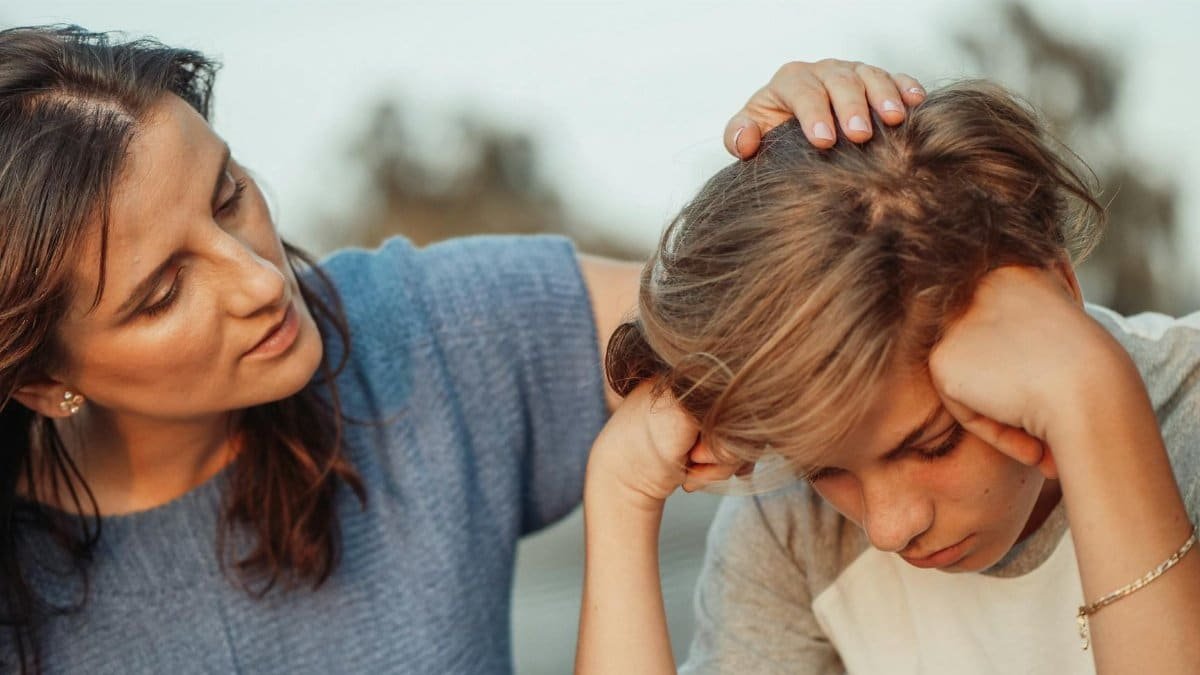 A mother offers support to her discouraged teenager son, portraying love and understanding.