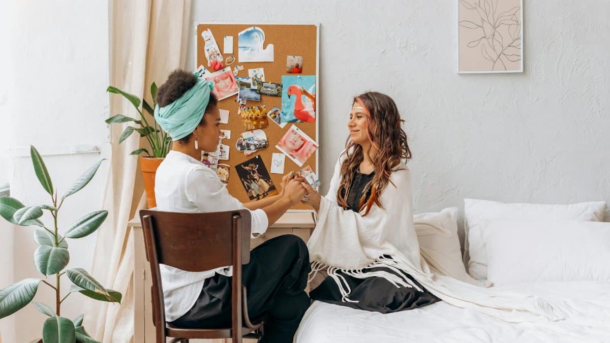 Two women sharing a mindful and spiritual moment in a cozy, indoor setting, promoting wellness and connection.