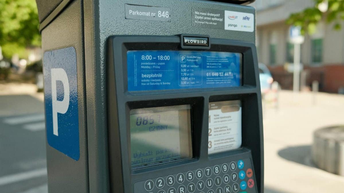Close-up of a parking meter with digital interface in a city street.
