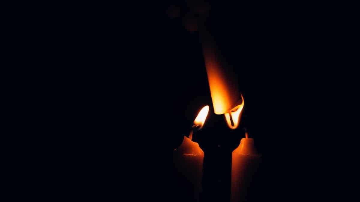 Close-up of candle flames against a dark background, offering warm illumination.