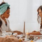 Three women engaging in a spiritual meditation session indoors with candles and crystals.