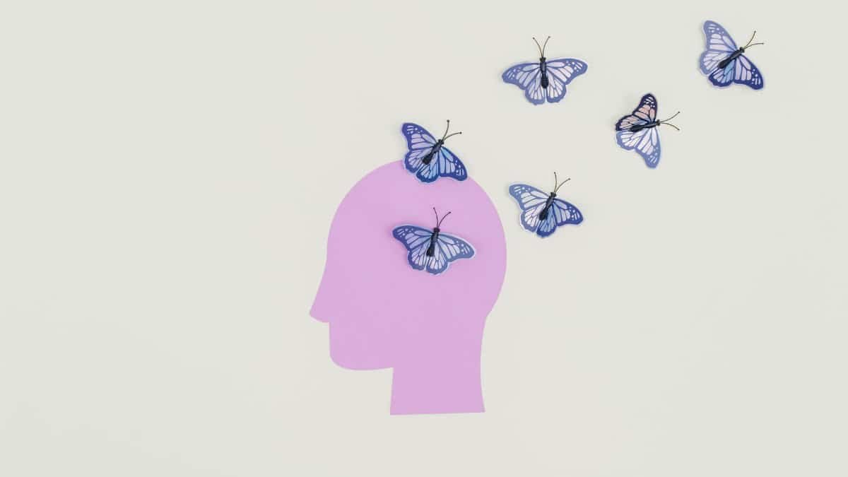 Abstract art of butterflies emerging from a silhouette head representing imagination and freedom.