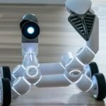 Close-up of a wheeled robot toy with a spotlight in an indoor setting, showcasing modern technology.