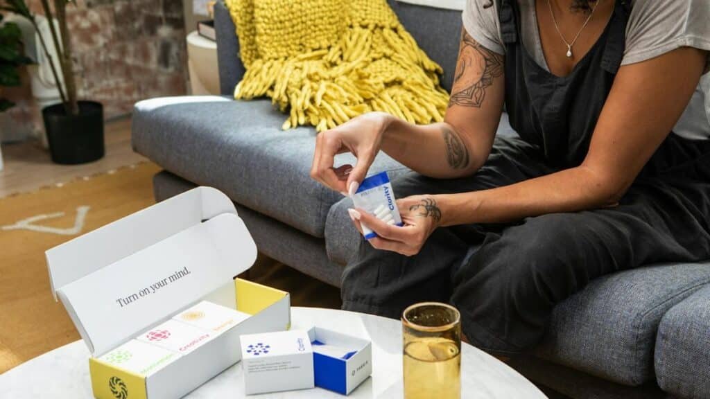 A woman sitting on a sofa examining nootropic supplements, promoting wellness and clarity.