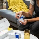 A woman sitting on a sofa examining nootropic supplements, promoting wellness and clarity.