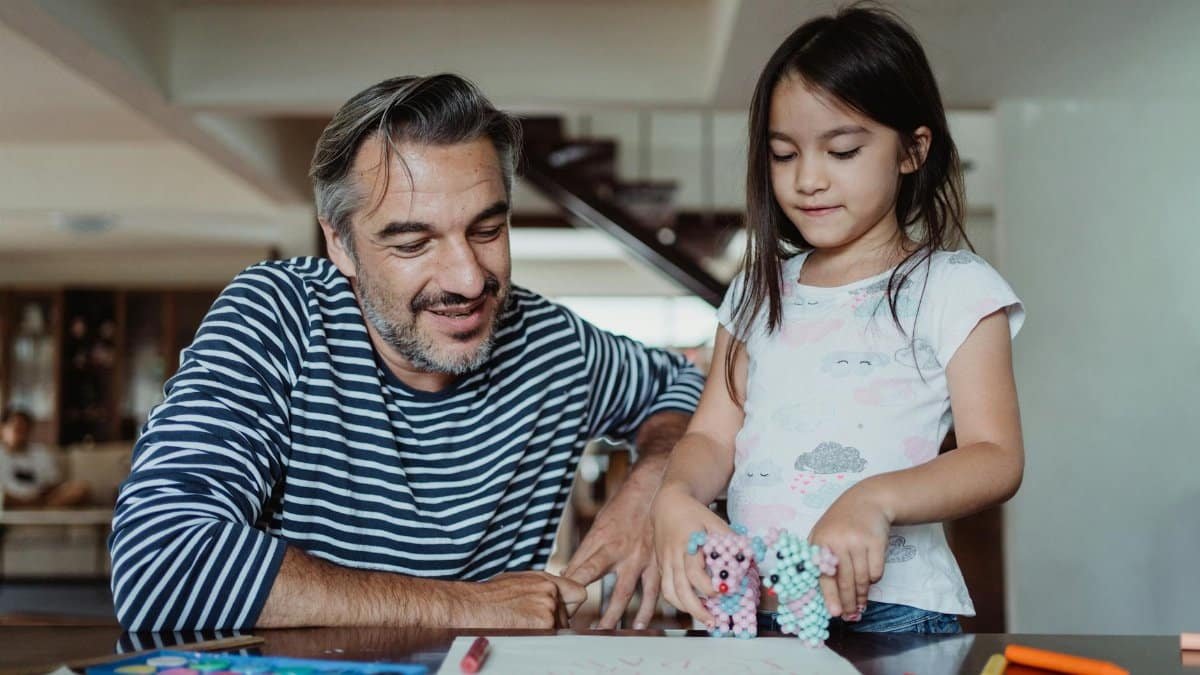 A joyful father and daughter bonding while engaging in creative activities at home.