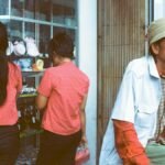 Casual street scene in Way Halim with two women at store and a man in front, capturing daily life.