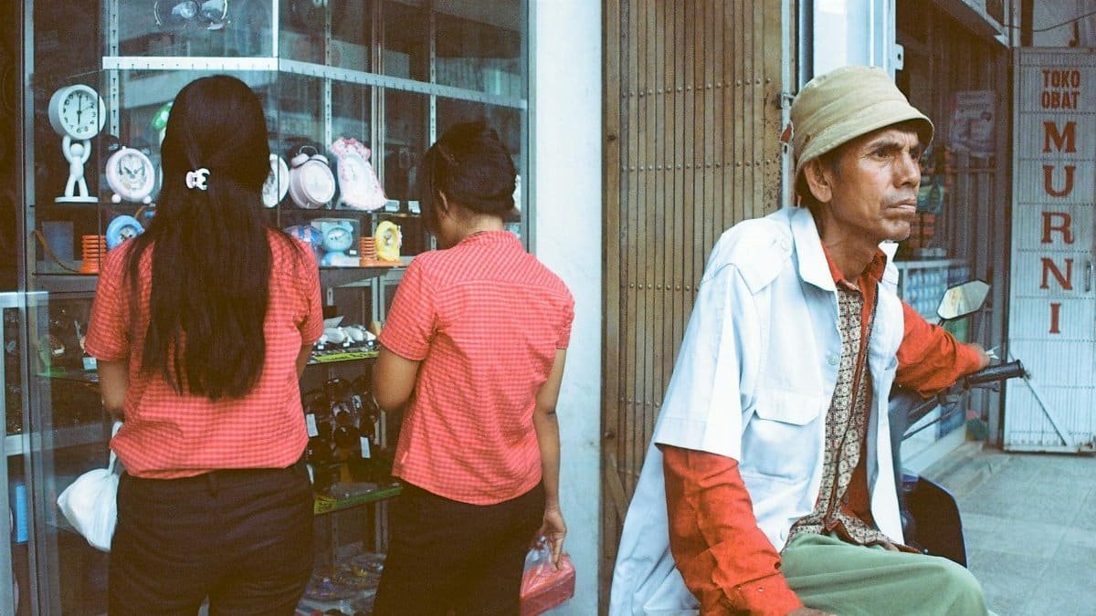 Casual street scene in Way Halim with two women at store and a man in front, capturing daily life.