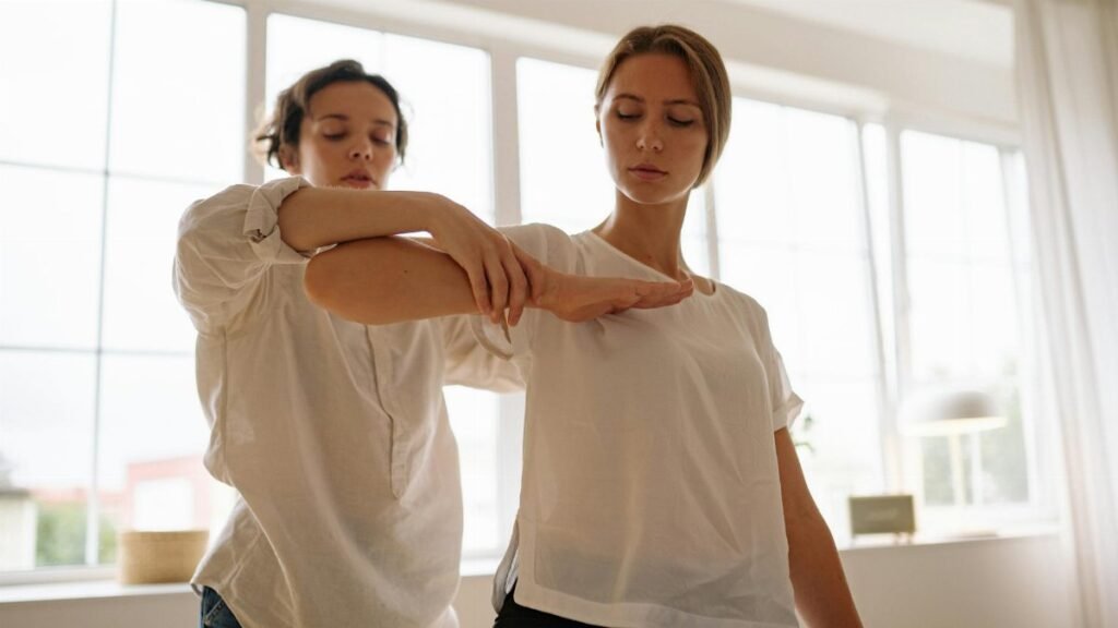 Two women participating in a therapy session indoors, focusing on relaxation and wellness.