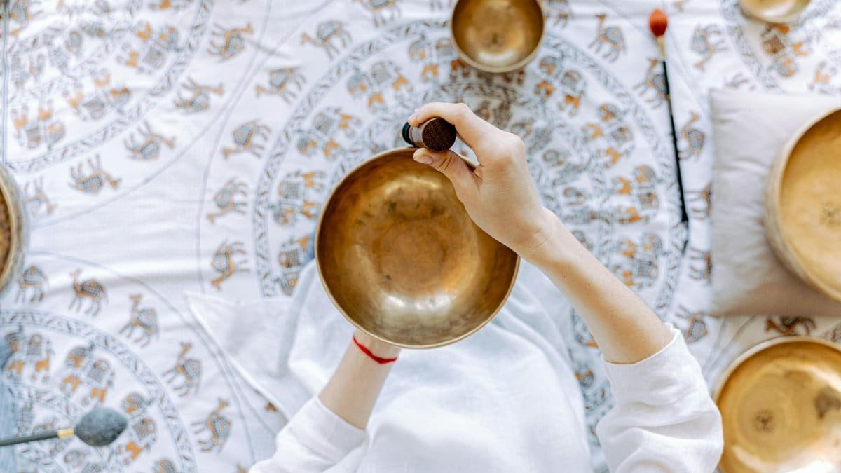 A top-down view of meditation using a Tibetan singing bowl for relaxation and healing.