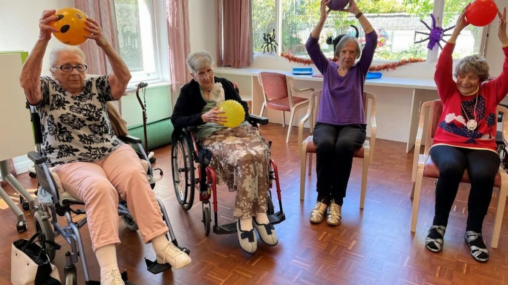 Elderly women engaging in fitness activities with exercise balls in a community center.