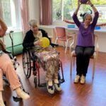 Elderly women engaging in fitness activities with exercise balls in a community center.
