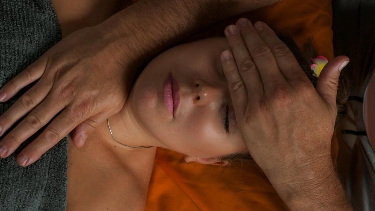 A serene close-up of a woman receiving a reiki massage for ultimate relaxation and wellness.