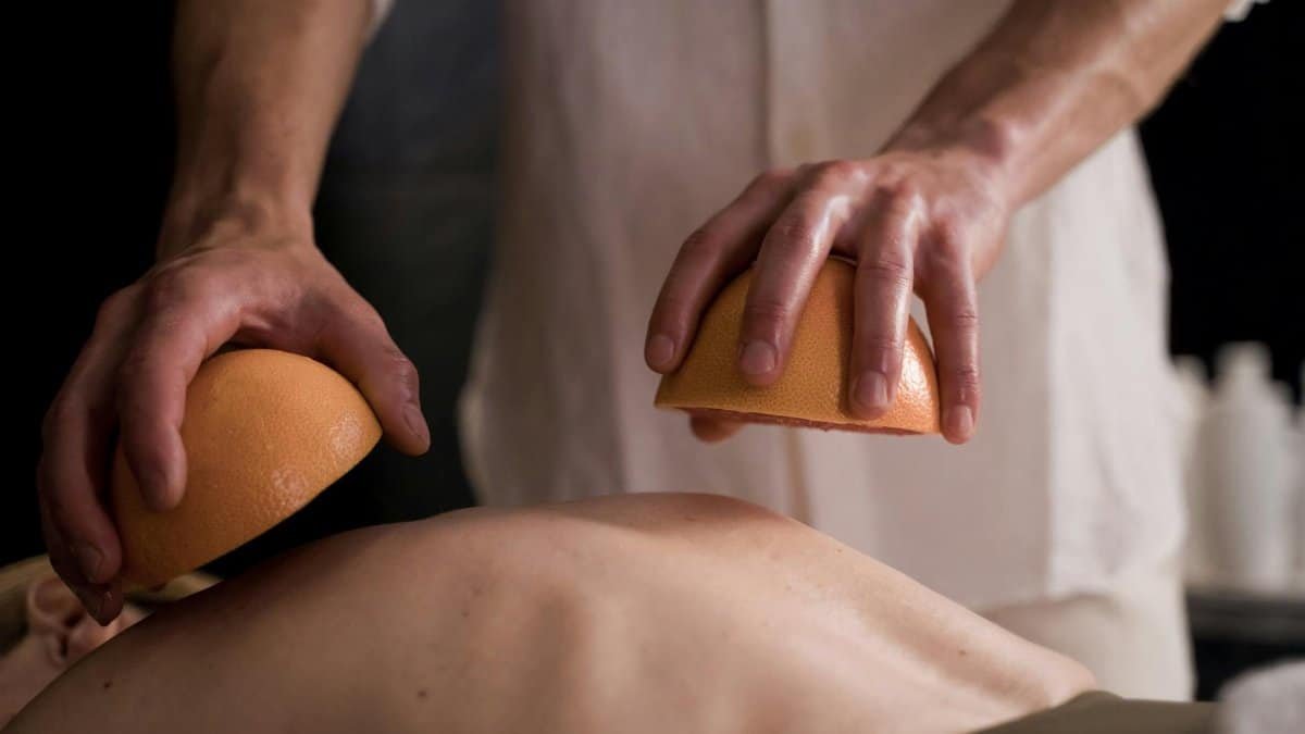 A soothing spa massage using grapefruits for relaxation and self-care.