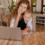 Woman multitasking while working from home with child. Relaxed ambiance.