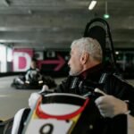 Senior man driving a go-kart indoors, showcasing the excitement of kart racing.