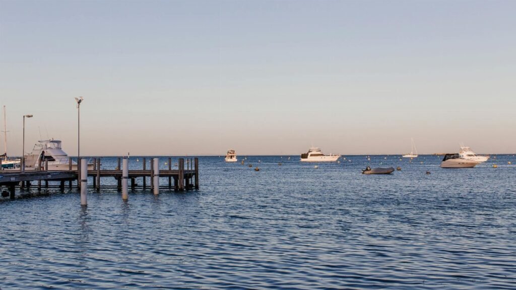 Calm sea with boats at the marina during a clear day, ideal for stock imagery.