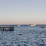 Calm sea with boats at the marina during a clear day, ideal for stock imagery.