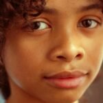 Captivating close-up portrait of a young girl with curly hair and soft expression in Los Angeles.