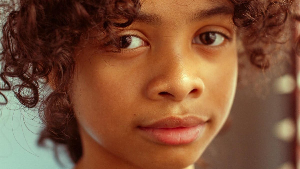 Captivating close-up portrait of a young girl with curly hair and soft expression in Los Angeles.