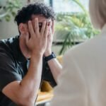 Man seeking support in therapy, expressing emotions during an indoor counseling session.