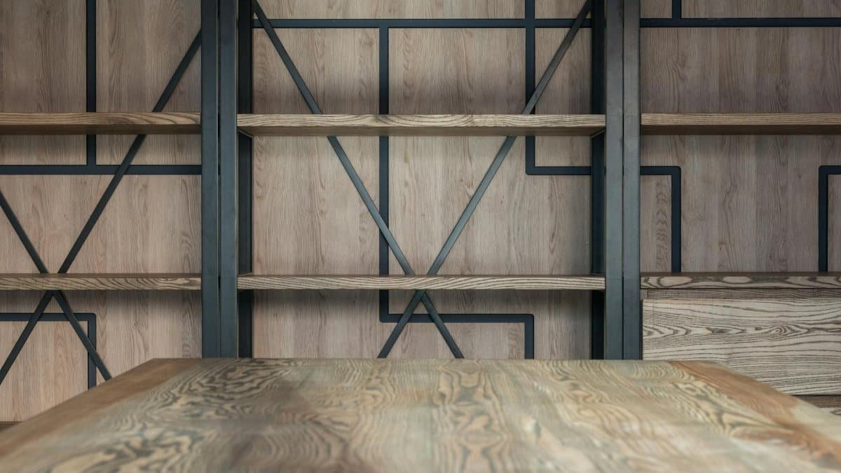 Empty wooden shelves near wall with decorative elements and table in modern spacious loft styled conference hall