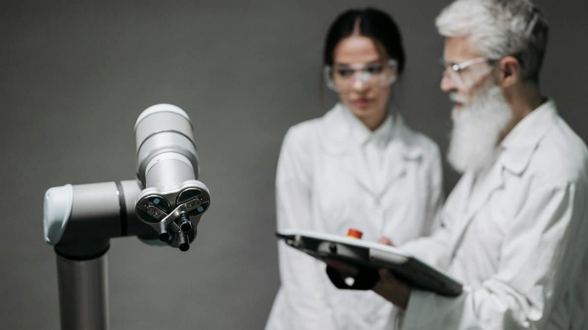 Researchers in lab coats analyze robotic equipment for technological advancement.