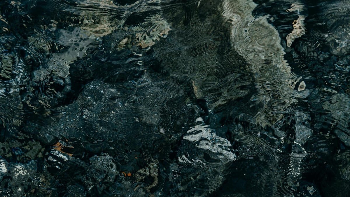 Abstract close-up of rippling dark water creating intricate texture and patterns.