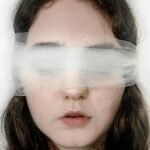 Close-up of a blindfolded woman with a serene expression, exploring themes of introspection.