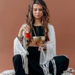 A serene woman meditates with a singing bowl, evoking a sense of peace and balance.
