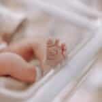 Close-up of a newborn's foot in a hospital cradle, capturing the tenderness of new life.
