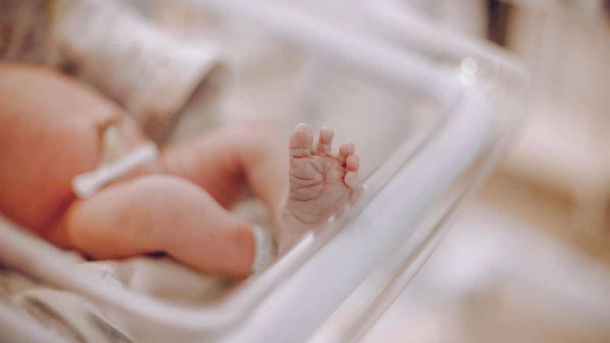 Close-up of a newborn's foot in a hospital cradle, capturing the tenderness of new life.