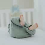 Cute baby feet in pajamas on a soft white crib. Perfect for children's room decor.