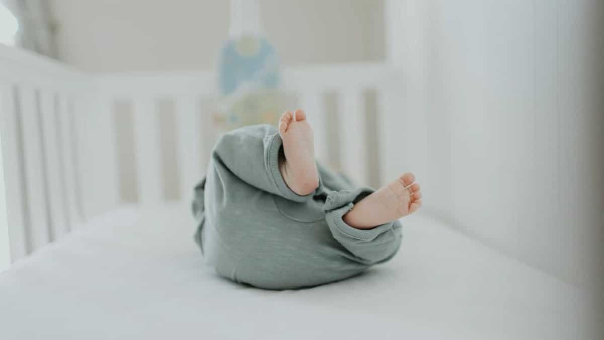 Cute baby feet in pajamas on a soft white crib. Perfect for children's room decor.