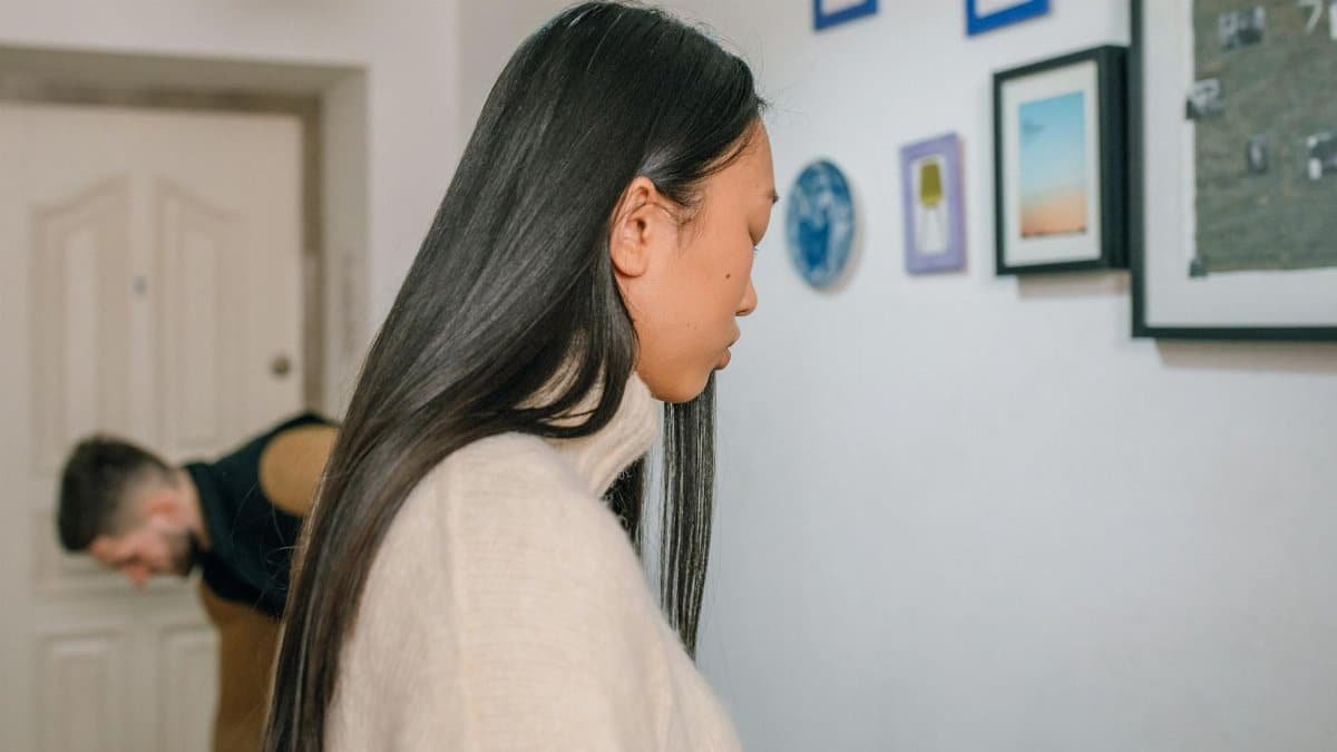 A couple in a modern apartment experiencing emotional tension, highlighting relationship struggles.