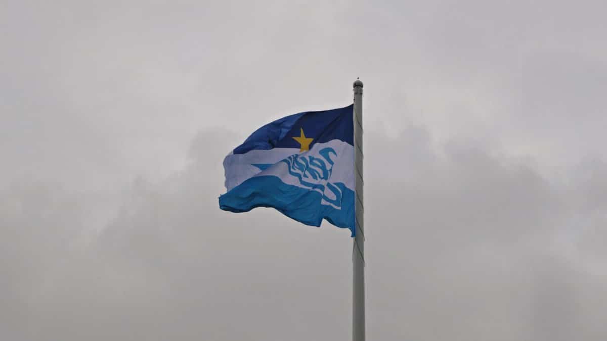 The flag of St. Petersburg fluttering against a cloudy sky, symbolizing regional identity.