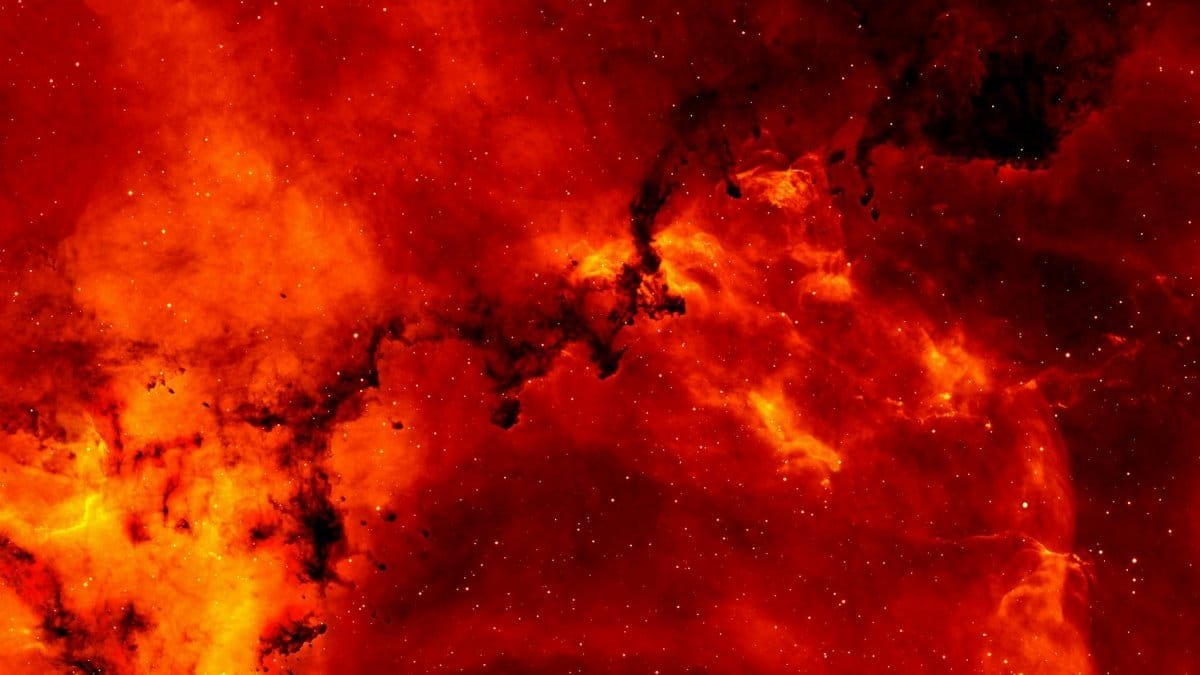 A stunning view of a red cosmic nebula, glowing intensely against a backdrop of stars.