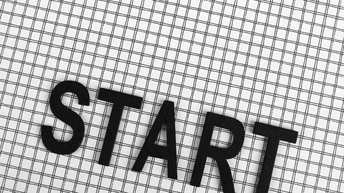 Black letters spelling 'START' on a white grid background, conceptual and minimalistic design.
