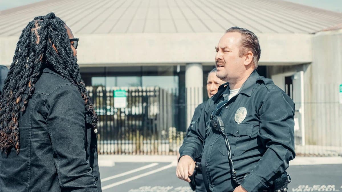 Police officers interacting with a civilian outside a public building, emphasizing community relations.