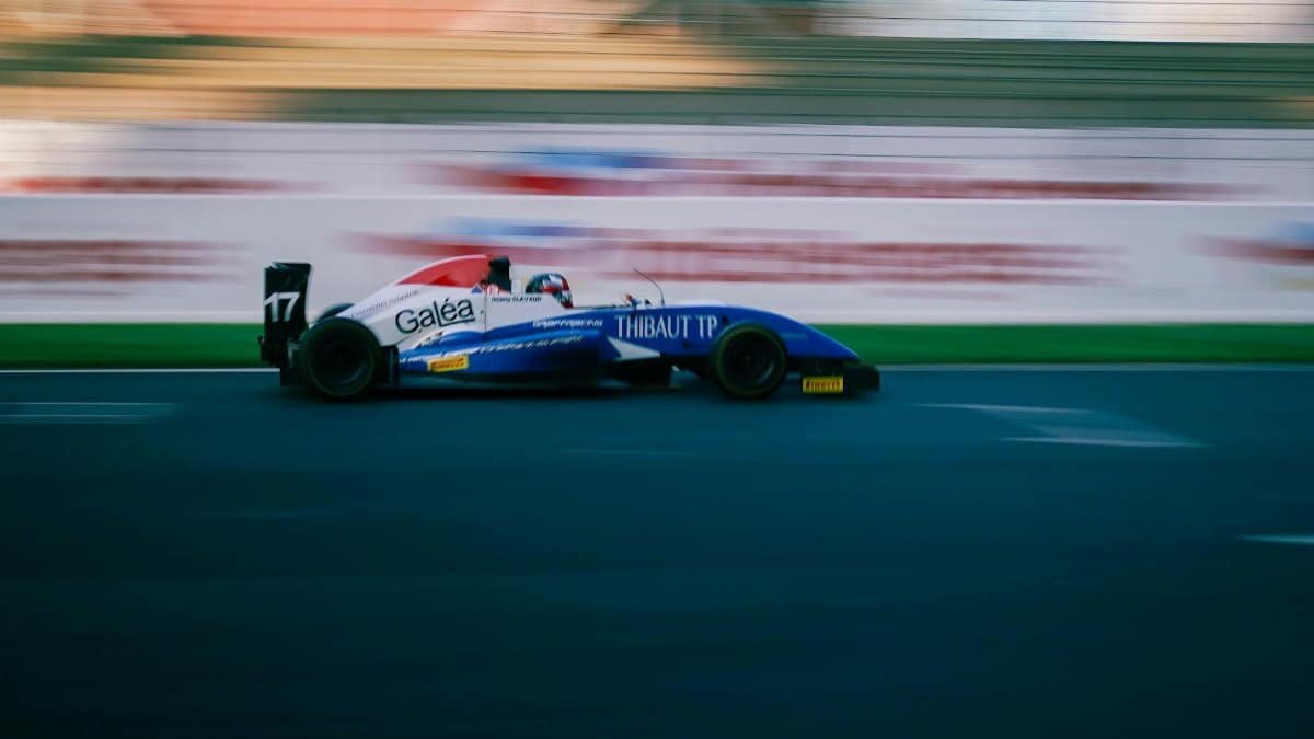 High-speed racing car on a circuit track showcasing motion blur and vibrant colors.