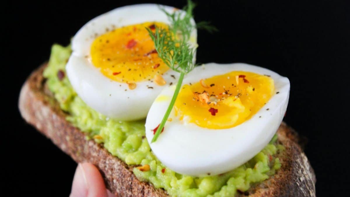 A delicious and healthy avocado toast topped with soft-boiled eggs, perfect for a nutritious breakfast.