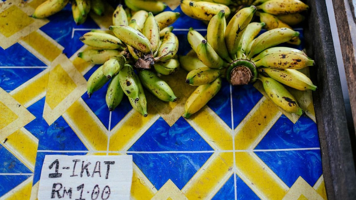 Bunches of ripe bananas displayed on a vibrant blue and yellow market table.
